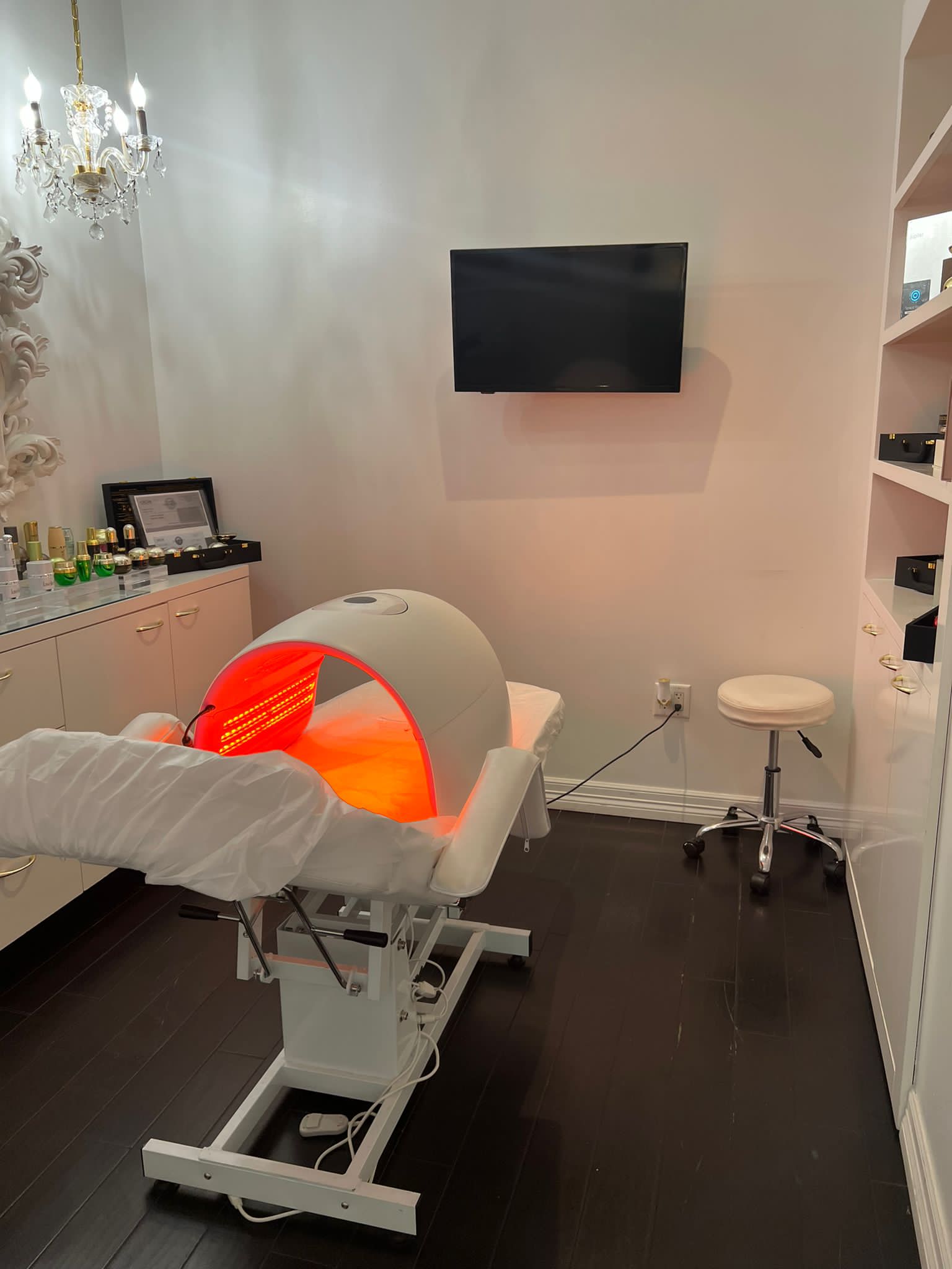 A treatment room at Donna Ella Spa with light therapy equipment and white furnishings